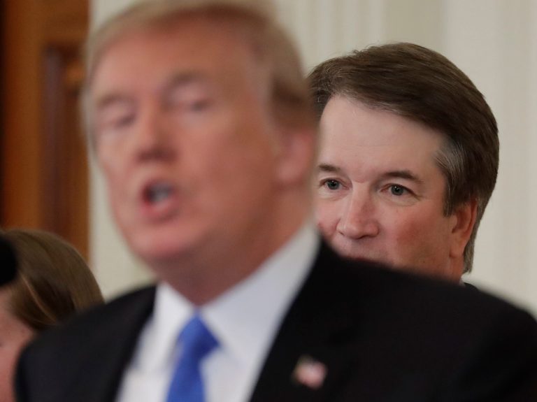 In this July 9, 2018, photo, President Donald Trump speaks as Judge Brett Kavanaugh his Supreme Court nominee, listens in the East Room of the White House in Washington. After a vicious fight, Kavanaugh is expected to win his confirmation Saturday.