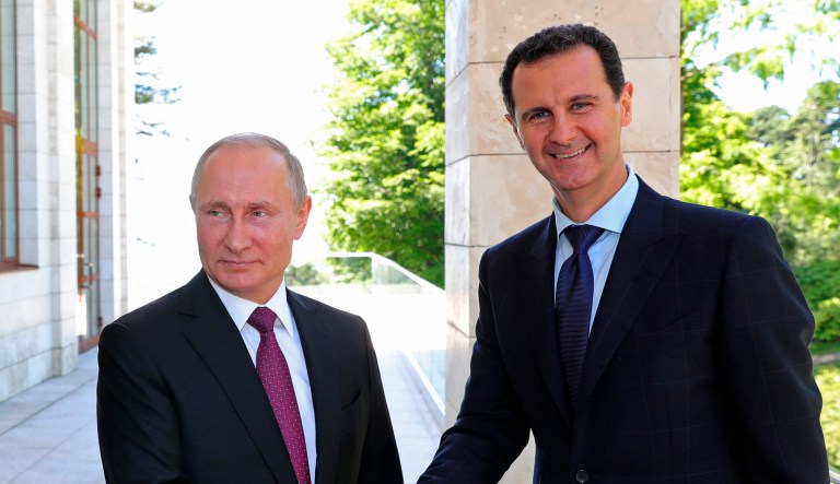 Russian President Vladimir Putin (left) shakes hands with Syrian President Bashar Assad during a meeting.