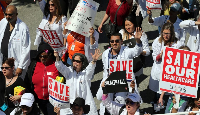 Healthcare professionals join hundreds of people marching through downtown Los Angeles protesting President Trump's plan to dismantle the Affordable Care Act. 