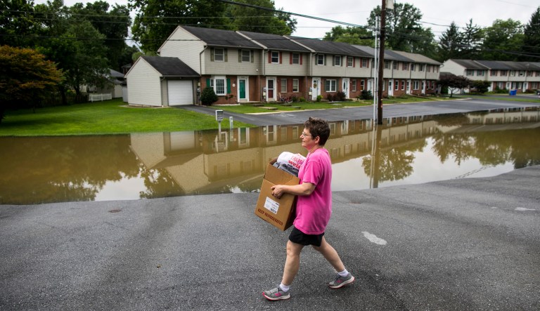 Michelle Laudermilch carries personal belongings to her car as she is asked to evacuate her home in Hummelstown due to flooding on the Swatara Creek near Hershey, Pa., on July 25.