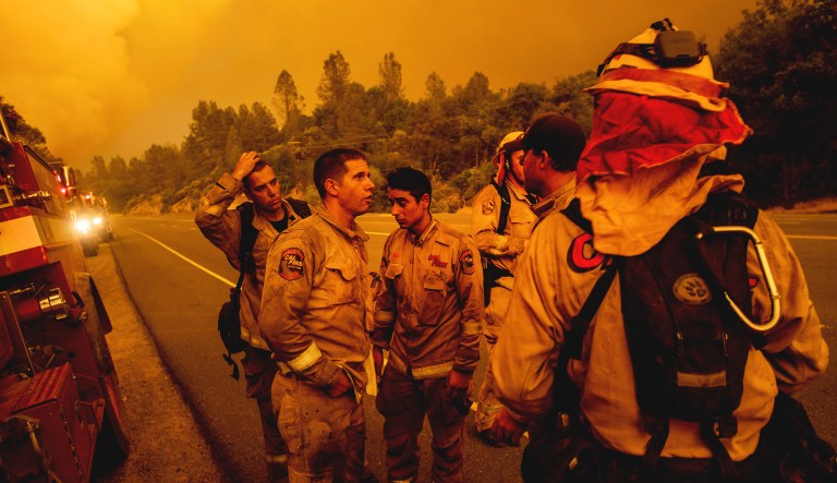 Firefighters discuss plans while battling the Carr Fire in Shasta, Calif., on Thursday.