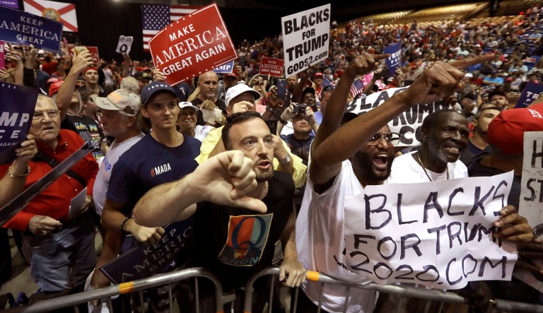 In this Tuesday, July 31, 2018, file photo, supporters of President Donald Trump shout down a CNN news crew before a rally in Tampa, Fla. Amid the "Trump 2020" placards, the "Women for Trump" signs and the "CNN SUCKS" T-shirts.