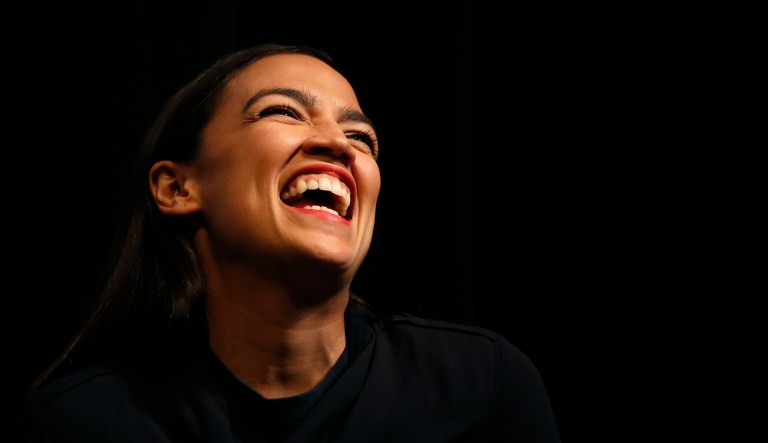 Democratic New York congressional candidate Alexandria Ocasio-Cortez laughs while listening to a speaker at a fundraiser, Aug. 2, 2018, in Los Angeles.