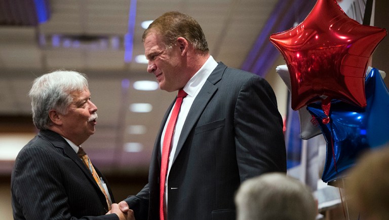 GOP chair Buddy Burkhardt, left, shakes the hand of libertarian-leaning Glenn Jacobs after early results showed Jacobs winning the mayoral race in Knoxville, Tenn.