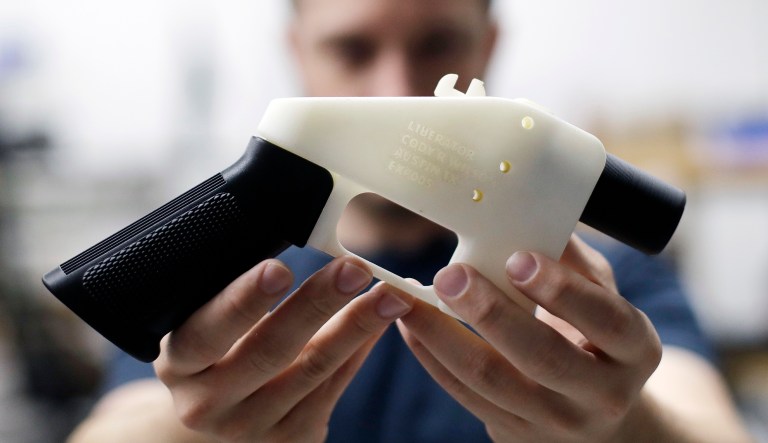 In this Aug. 1, 2018, photo, Cody Wilson, with Defense Distributed, holds a 3D-printed gun called the Liberator at his shop in Austin, Texas.