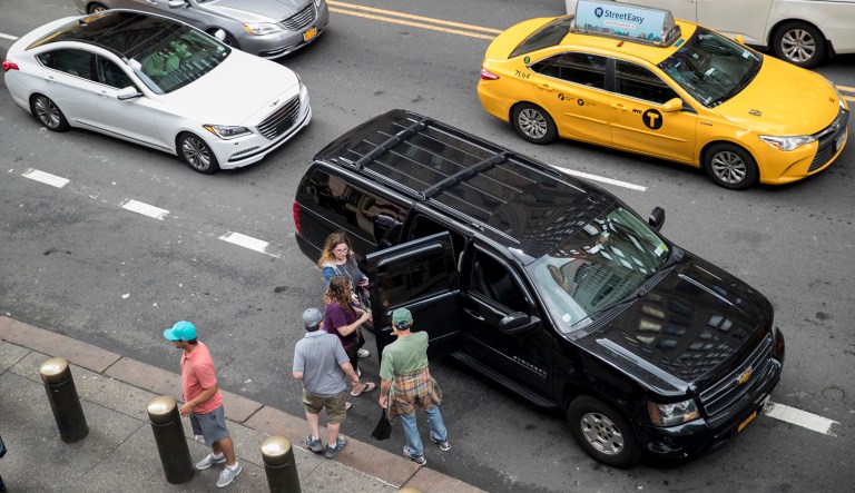 In this Wednesday, Aug. 1, 2018 photo, traffic on 42nd Street makes it's way around a ride-hailing car picking up passengers outside Grand Central Terminal in New York.
