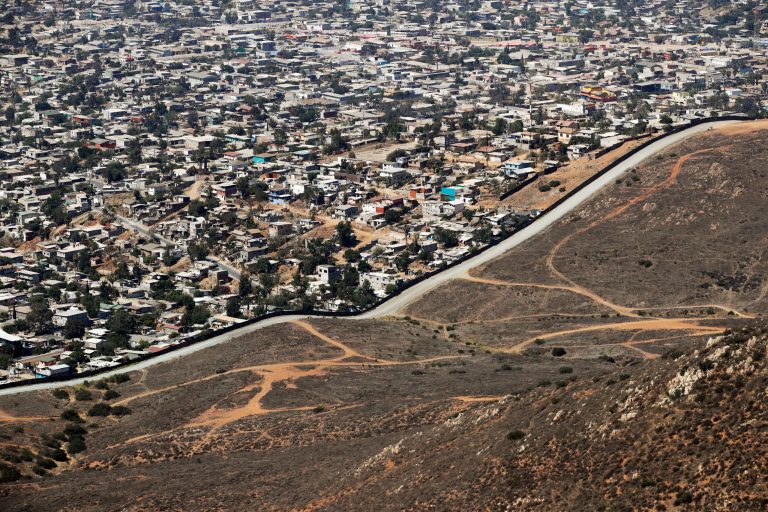 FILE - In this Thursday, June 28, 2018 file photo a road runs alongside a border wall that separates Tijuana, Mexico, top, from San Diego. A congressional watchdog agency says the Trump administration's plan to erect hundreds of miles of barriers along the border with Mexico fails to adequately consider costs, potentially raising the price and creating delays. The Government Accountability Office said Monday, Aug. 6, 2018, that costs can vary considerably based on the slope and topography, land acquisition costs and other factors.
