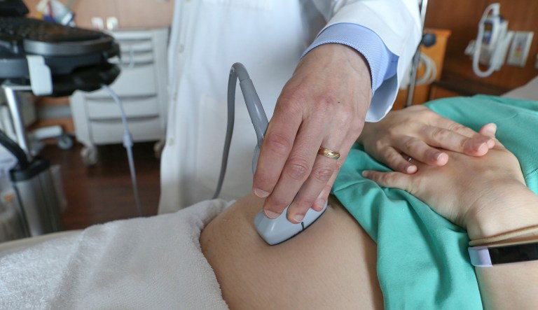 In this Aug. 7, 2018 photo, a doctor performs an ultrasound scan on a pregnant woman at a hospital in Chicago. According to a study released on Wednesday, Aug. 8, 2018, first-time mothers at low risk of complications were less likely to need a cesarean delivery if labor was induced at 39 weeks instead of waiting for it to start on its own. Their babies fared better, too.