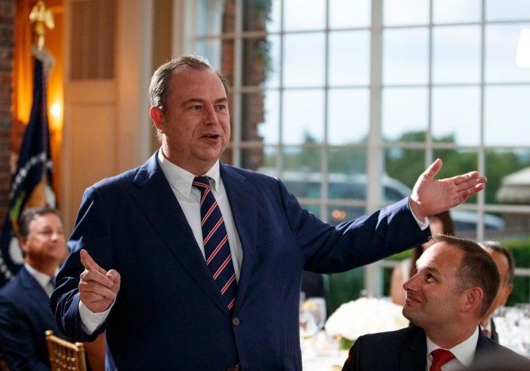 Newsmax CEO Chris Ruddy speaks during a dinner meeting with President Donald Trump and other business leaders, Tuesday, Aug. 7, 2018, at Trump National Golf Club in Bedminster, N.J. His outlet was just picked up by Comcast.
