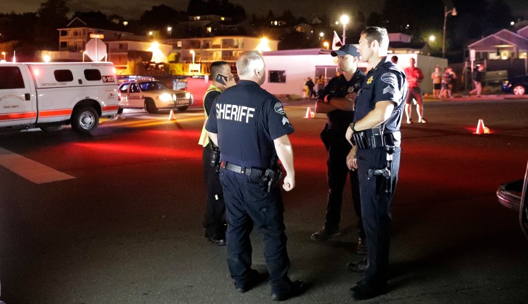 Law enforcement officials stand at a staging area at the ferry terminal in Steilacoom, Wash., near where a Coast Guard spokeswoman said the agency was responding to a report of a smoke plume and possible plane crash. Earlier in the evening, officials at Seattle-Tacoma International Airport said an Alaska Airlines plane had been stolen and later crashed.