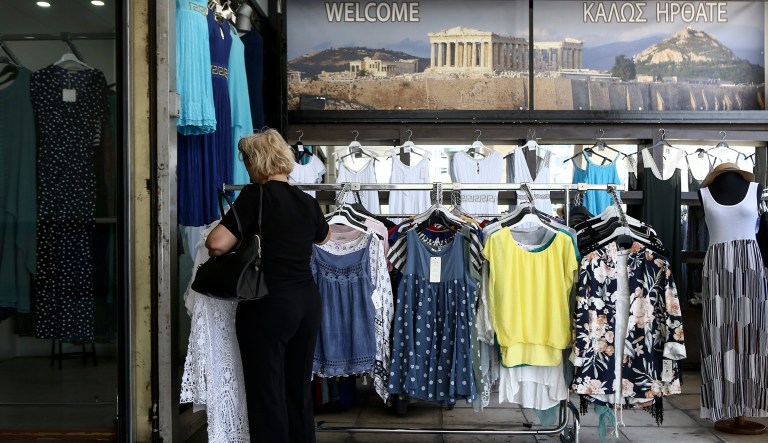 A woman browses around a store in central Athens, Monday, Aug. 20, 2018, on the day that Greece's eight-year crisis will be officially over.  Despite this deadline few Greeks see cause for celebration, though the economy is once again growing modestly and state finances are improving, exports are up and unemployment is down from a ghastly 28 percent high.