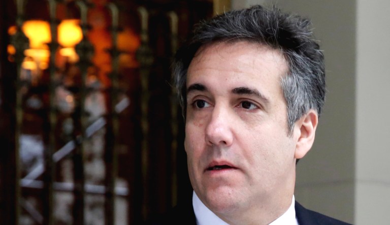Michael Cohen walks out of a building.