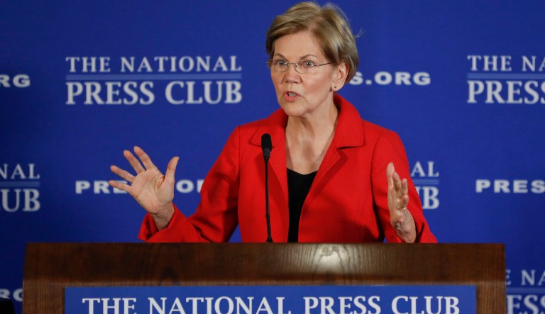 Sen. Elizabeth Warren, D-Mass., gestures while speaking at the National Press Club in Washington, Tuesday, Aug. 21, 2018. Warren wants a lifetime ban on members of Congress from getting hired as lobbyists after they leave public office. She also wants to prohibit lawmakers from owning or trading individual stocks while in office. 