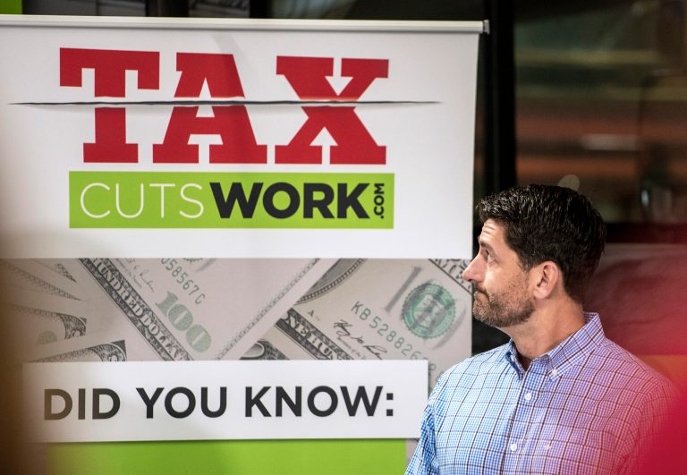 House Speaker Paul Ryan glances back at a sign at the "Tax Cuts Work" event at Jakes Electric in Clinton, Wis., Friday, Aug. 24, 2018. (Angela Major/The Janesville Gazette via AP)