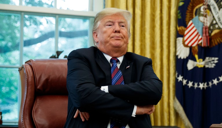 President Donald Trump crosses his arms after speaking with Mexican President Enrique Pena Nieto on the phone about a trade agreement between the United States and Mexico, in the Oval Office of the White House, Monday, Aug. 27, 2018, in Washington. Trump has bowed to widespread pressure from veterans groups and others to do more to honor John McCain's death. Trump on Monday ordered flags at the White House and elsewhere lowered to half-staff until the six-term senator is buried Sunday. He also proclaimed "respect" for McCain, with whom he feuded bitterly for years. It was a marked reversal from Trump's refusal to comment on McCain.