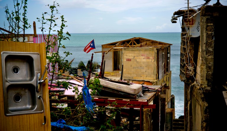 A Puerto Rican national flag is shown amid debris after a hurricane.