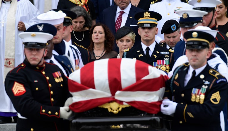 The casket of Sen. John McCain, R-Ariz., is carried out of the Washington National Cathedral in Washington, Saturday, Sept. 1, 2018, after a memorial service, as Cindy McCain is escorted by her son Jimmy McCain and other family members. 