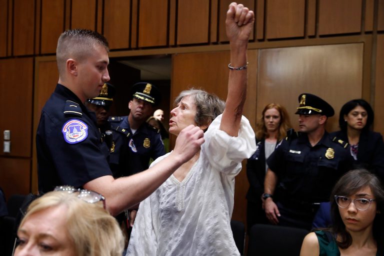 A woman stands and voices her opposition to Supreme Court nominee Brett Kavanaugh, during a Senate Judiciary Committee confirmation hearing on his nomination for Supreme Court, on Capitol Hill, Tuesday, Sept. 4, 2018, in Washington.