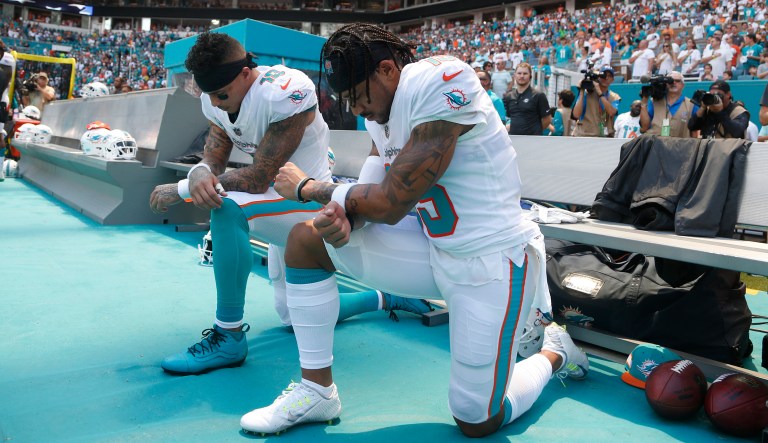 Miami Dolphins wide receiver Kenny Stills (10) and Miami Dolphins wide receiver Albert Wilson (15) kneel during the national anthem before an NFL football game against the Tennessee Titans, Sunday, Sept. 9, 2018, in Miami Gardens, Fla. 