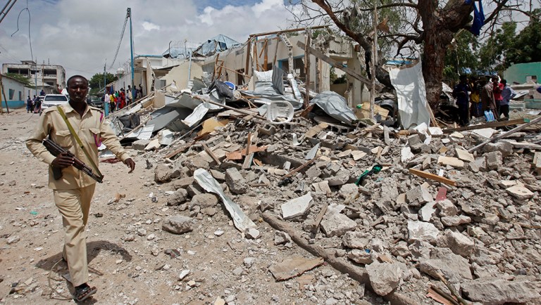 A police officer walks past the rubble of a destroyed building at the scene of a blast outside a district headquarters in the capital Mogadishu, Somalia.