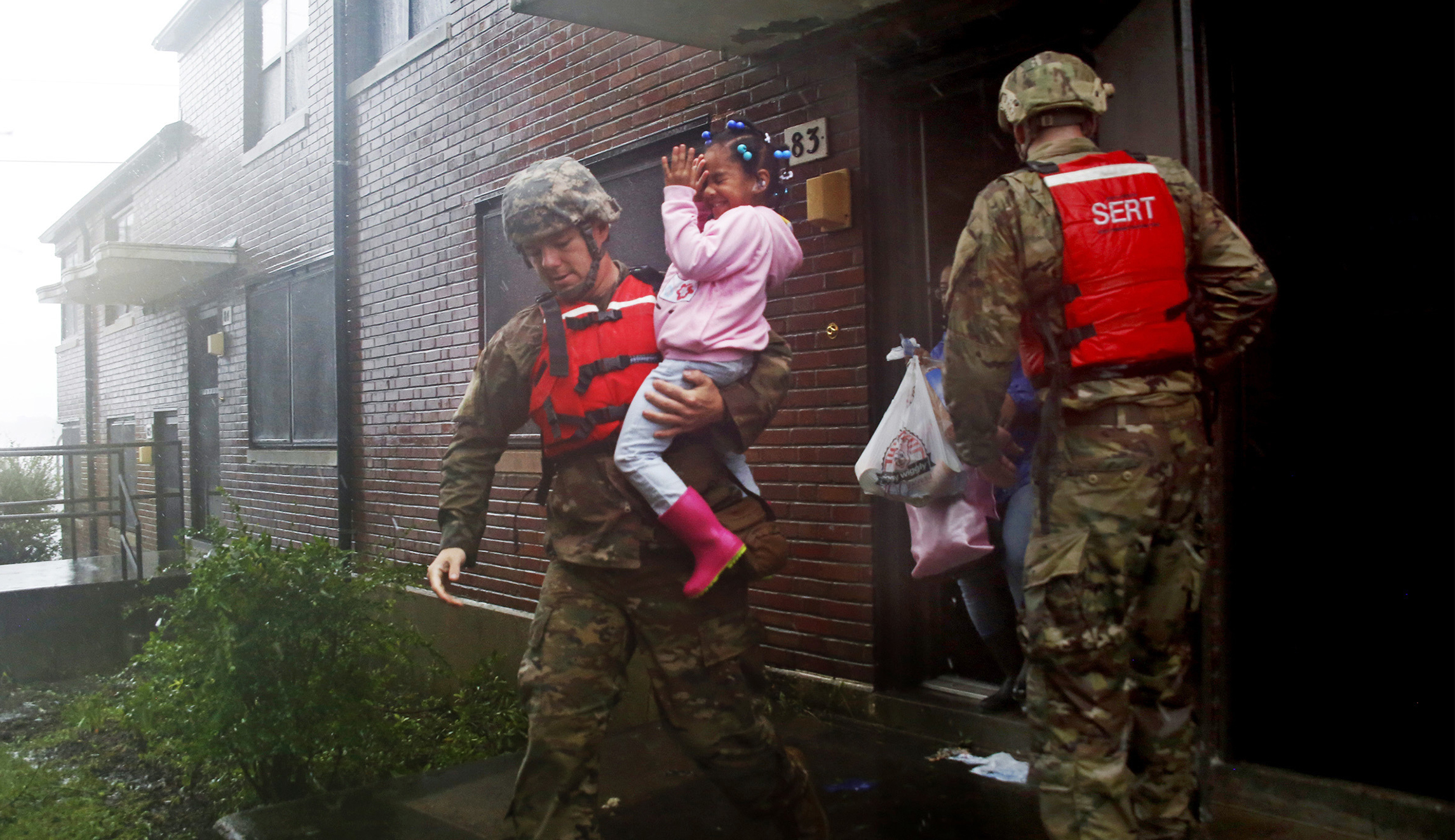 A rescue team from the North Carolina National Guard 1/120th battalion evacuates a family as the rising floodwaters from Hurricane Florence threatens their home in New Bern, N.C., on Friday.
