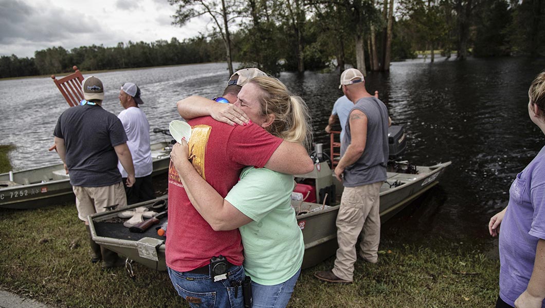 Justin Humphrey, 24, hugs his mother Michelle Paddock, 45, while removing possessions from her flooded home.