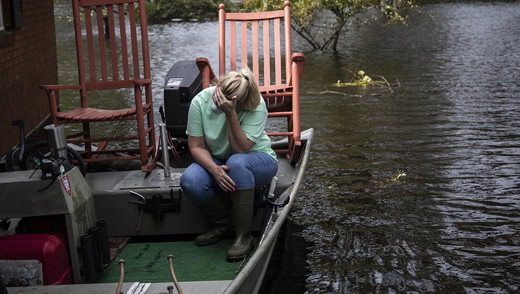 Michelle Haddock reacts while removing possessions from her flooded home in Trenton, N.C.
