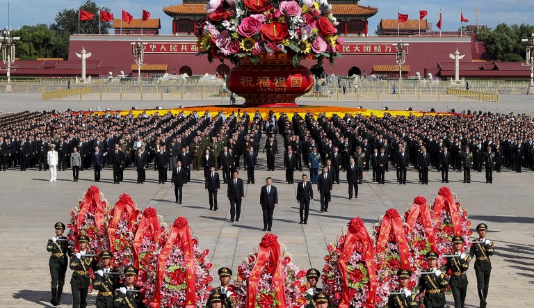 In this photo released by Xinhua News Agency, Chinese President Xi Jinping, center, is followed by high-ranking officials walk toward to the Monument to the People's Heroes during a ceremony marking Martyrs Day at Tiananmen Square in Beijing, Sunday, Sept. 30, 2018. Xi and other Chinese leaders presented flower baskets and scores of ordinary people filed up to lay a single flower each at the Peoples Heroes Monument in central Beijing to mark Martyrs Day.