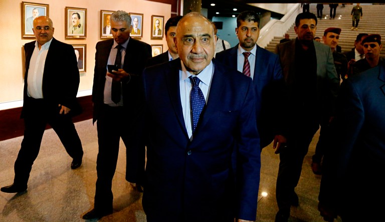 Iraq's new Prime Minister Adel Abdul-Mahdi, center, leaves the parliament building in Baghdad, Iraq, Tuesday, Oct. 2, 2018. Iraq's new president has tasked veteran Shiite politician Abdul-Mahdi with forming a new government nearly five months after national elections were held, state TV reported late Tuesday.