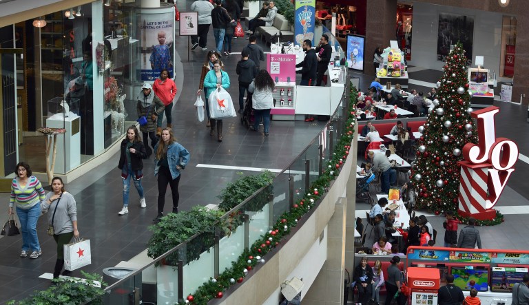 FILE- In this Dec. 22, 2017, file photo people shop at the Pentagon City Mall in Arlington, Va. The National Retail Federation, the nation's largest retail trade group, says it expects sales in November and December to rise as shoppers continue to be in a spending mood in a stronger economy.
