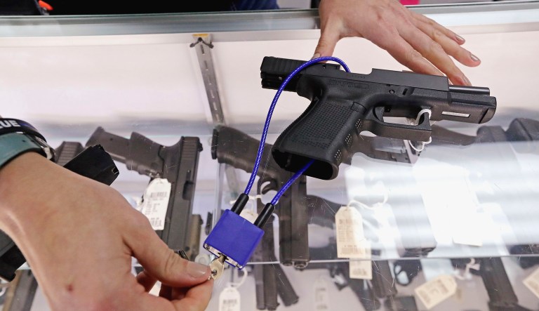 Gun shop owner Tiffany Teasdale demonstrates how a gun lock works on a handgun in Lynnwood, Washington.