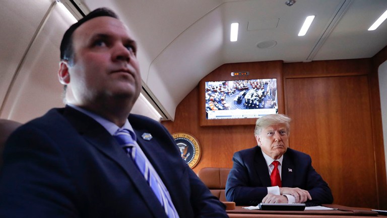 President Trump, on board Air Force One, watches a live television broadcast with White House Director of Social Media Dan Scavino.