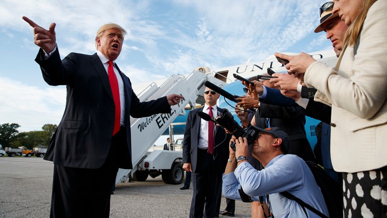 President Trump talks with reporters after arriving at Erie International Airport.
