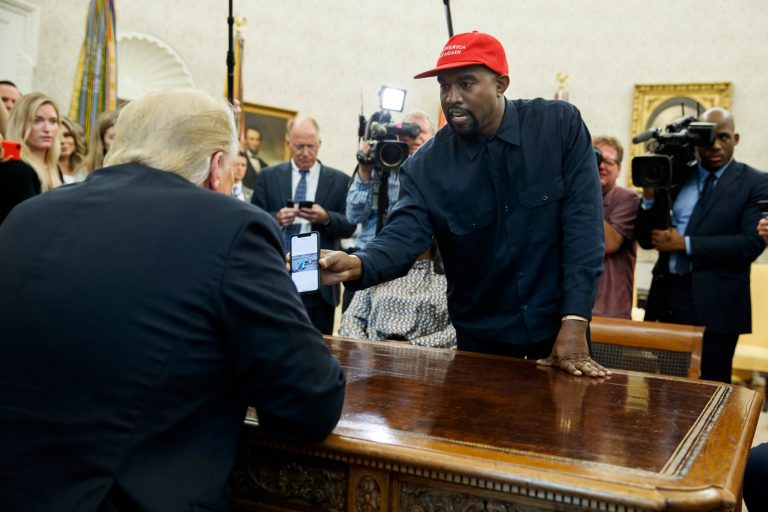 Rapper Kanye West shows President Donald Trump a photograph of a hydrogen plane during a meeting in the Oval Office of the White House, Thursday, Oct. 11, 2018, in Washington.