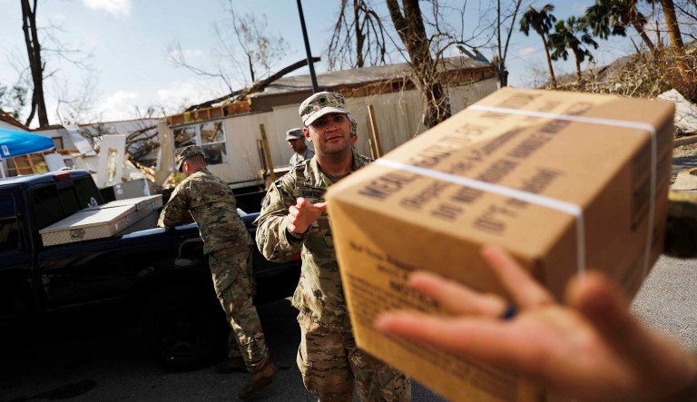 Soldiers with Florida National Guard's Bravo Company, 2nd Battalion, 124th Infantry Regiment, load food and water for the public at an aid distribution point in the wake of Hurricane Michael in Panama City, Fla., Monday, Oct. 15, 2018. 