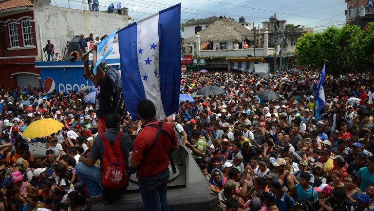 Thousands of Honduran migrants stream toward the border bridge in Tecun Uman, Guatemala, moments before the migrants broke down the gates at the Guatemala-Mexico border crossing and began streaming toward a bridge into Mexico.