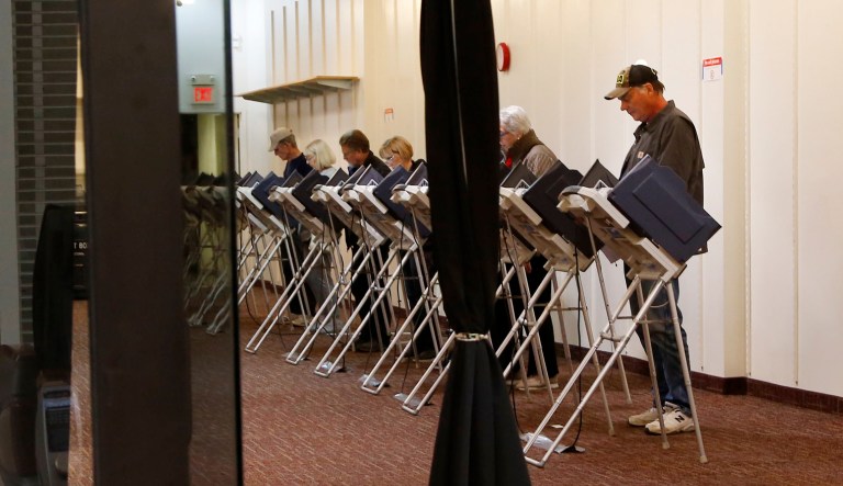People fill in their election ballots at an early voting poll at a mall in Bloomingdale, Illinois.