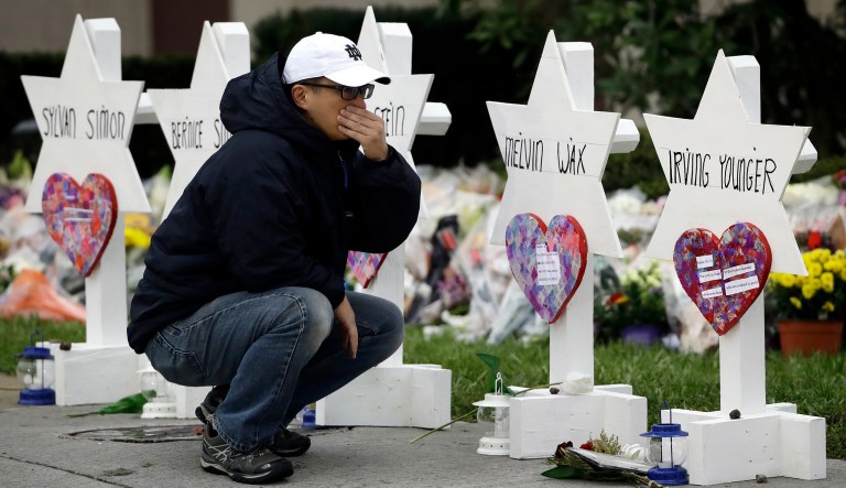 A person pauses in front of Stars of David with the names of those killed in a deadly shooting at the Tree of Life Synagogue, in Pittsburgh, Monday, Oct. 29, 2018. 