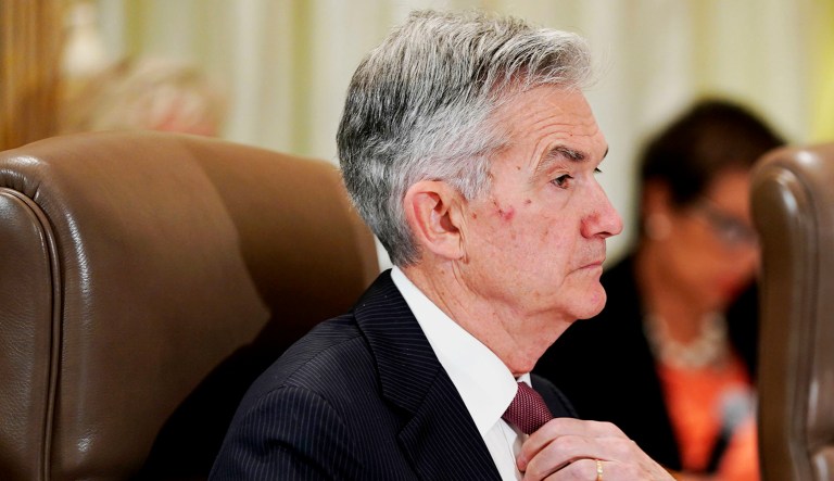 Federal Reserve Chairman Jerome Powell straightens his tie during a Federal Reserve Board meeting in D.C.