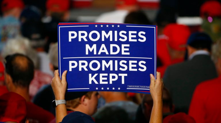 Supporters hold up signs as the wait to hear President Donald Trump speak at a campaign rally Saturday, Nov. 3, 2018, in Pensacola, Fla.