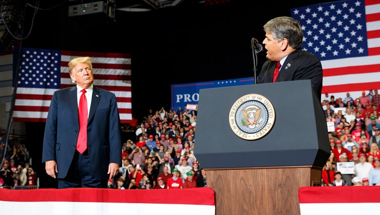 President Trump listens Fox News' Sean Hannity speak during a rally at Show Me Center.