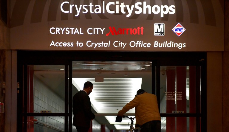 People enter through a doorway in Crystal City, Va. Amazon has announced that it will split its second headquarters between Long Island City in New York and Crystal City in northern Virginia. 