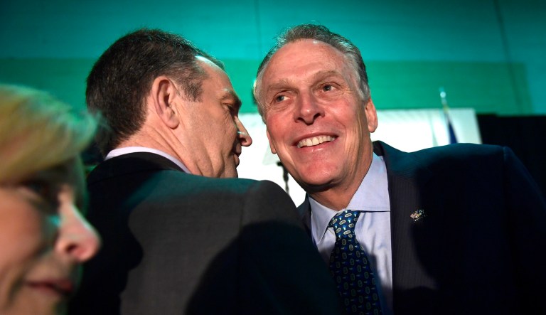 Virginia Gov. Ralph Northam, center, talks with former Virginia Gov. Terry McAuliffe, right, before the start of a news conference in the Crystal City neighborhood in Arlington, Va., Tuesday, Nov. 13, 2018.