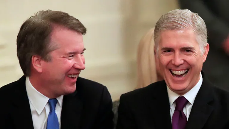 Supreme Court justices, left to right, Brett Kavanaugh and Neil Gorsuch talk with each other before the start of presentation of the Presidential Medal of Freedom.
