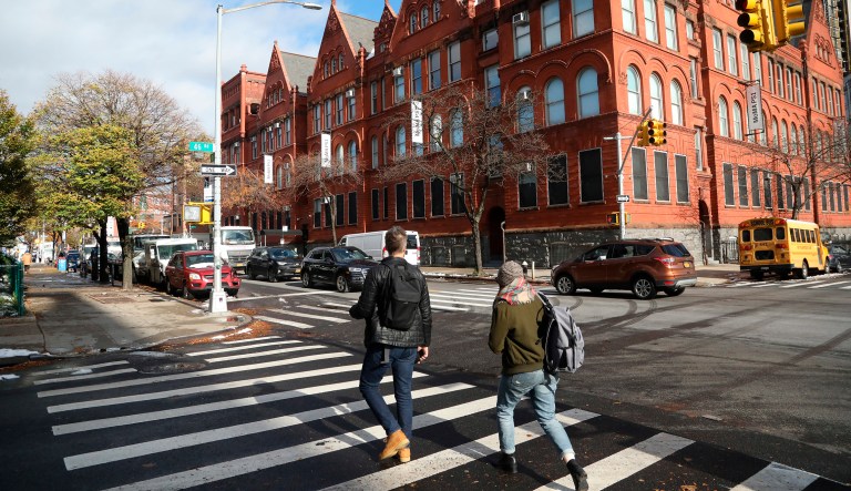People cross the street next to the MOMA PS1 art museum located in Long Island City near the site for a proposed Amazon headquarters in the Queens borough of New York, Friday, Nov. 16, 2018.
