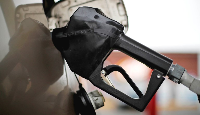This is a gas pump nozzel in a car filling up at a pump.