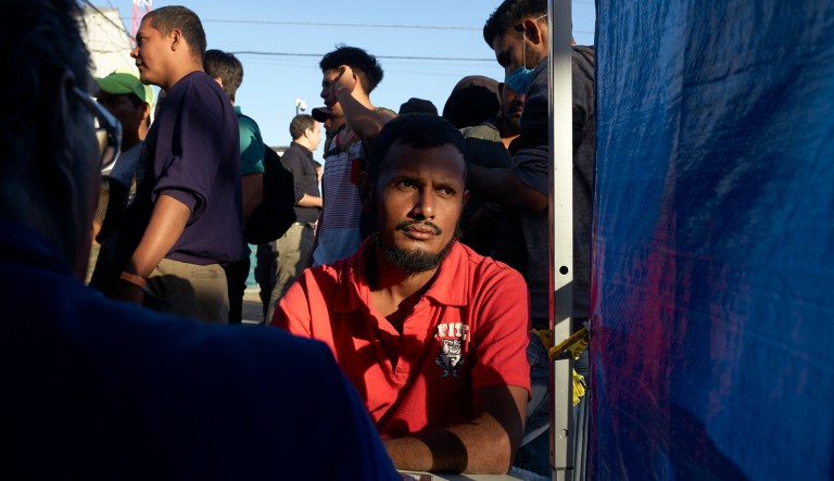 Omar Angel, of Honduras, fills out paper work to return home with the International Organization of Migration, in front of the shelter housing members of the migrant caravan, Monday, Nov. 26, 2018, in Tijuana, Mexico. A day after a march by members of the migrant caravan turned into an attempt to breach the U.S. border with Mexico, many migrants appeared sullen Monday, wondering whether the unrest had spoiled whatever possibilities they might have had for making asylum cases.