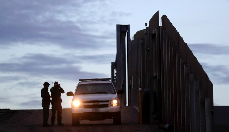 In this Wednesday, Nov. 21, 2018 file photo, United States Border Patrol agents stand by a vehicle near one of the border walls separating Tijuana, Mexico and San Diego, in San Diego.