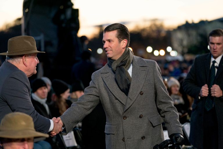 Donald Trump Jr. shakes hands with Agriculture Secretary Sonny Perdue, left, ahead of President Donald Trump and first lady Melania Trump for the National Christmas Tree lighting ceremony at the Ellipse near the White House in Washington, Wednesday, Nov. 28, 2018.