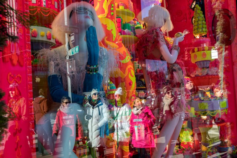 Pedestrians on Fifth Avenue are reflected in the windows of Bergdorf Goodman's Christmas display, Tuesday, Dec. 4, 2018, in New York.